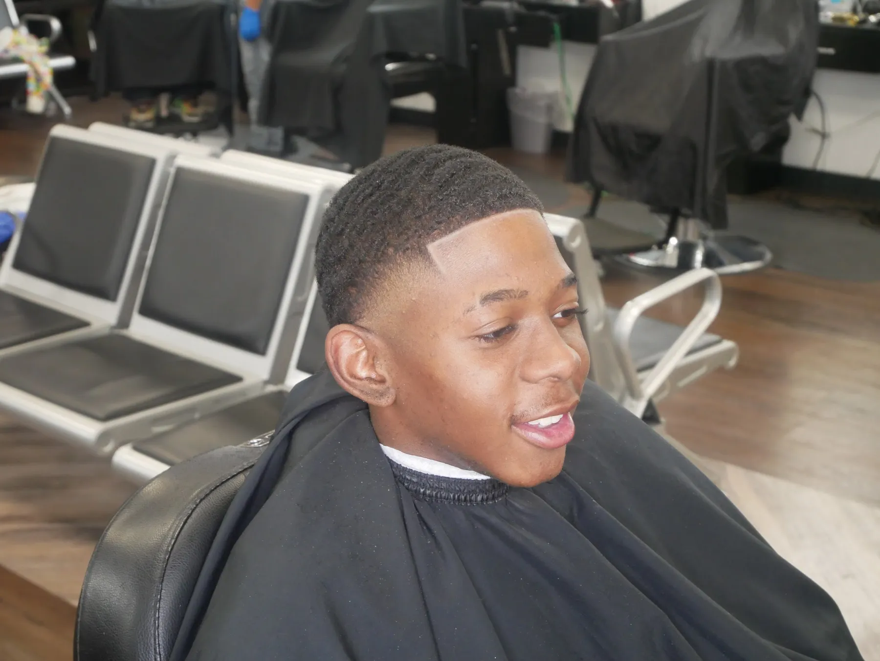 Smiling young client after a fresh fade at VIP Barber Lounge Aurora